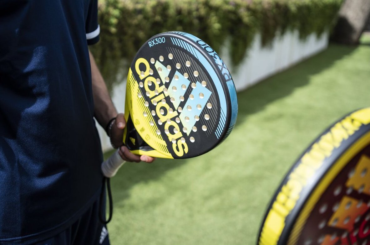 Bild på Adidas RX 300 2022 i handen på en padelspelare. Ett rundformat och lättspelat racket som passar för nybörjare.