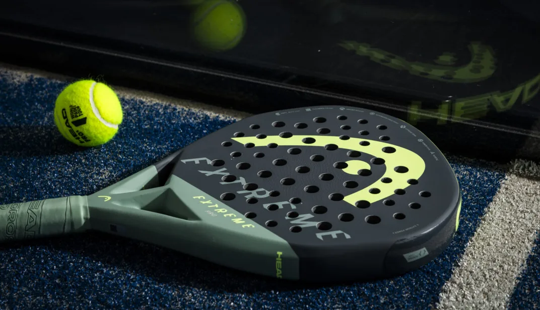 Padelracket HEAD Extreme Pro tillsammans med en padelboll på en padelbana.