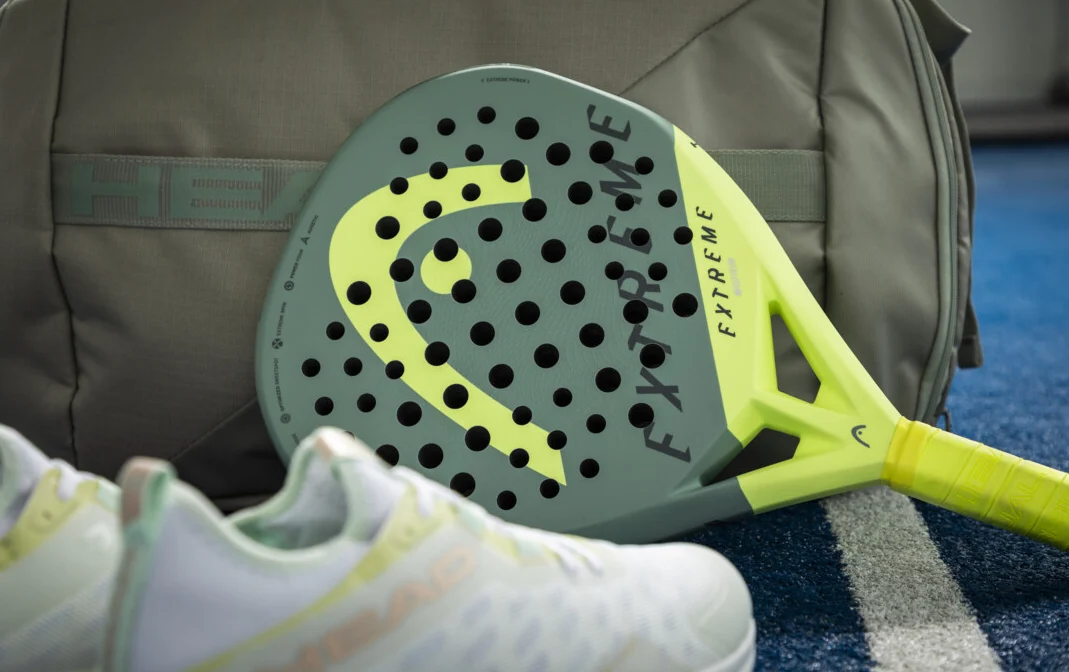 Bild på padelracket Head Extreme Motion när det ligger vi en padelväska och ett par padelskor.