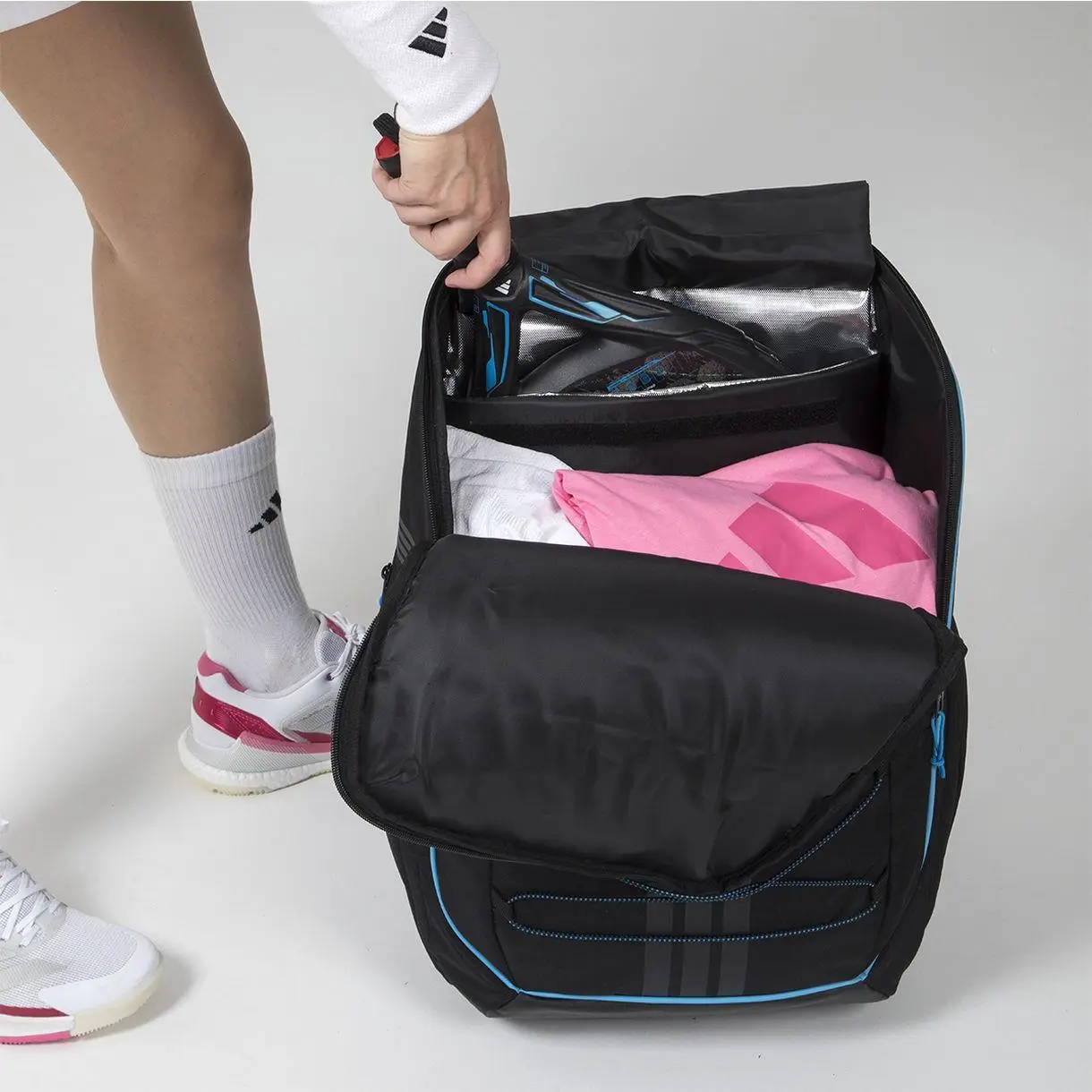 Här ser man när ett padelracket läggs i ryggsäcken Adidas Pro Tour 3.4 Backpack, som placerar sig högt upp i vårt padelryggsäck bäst i test.